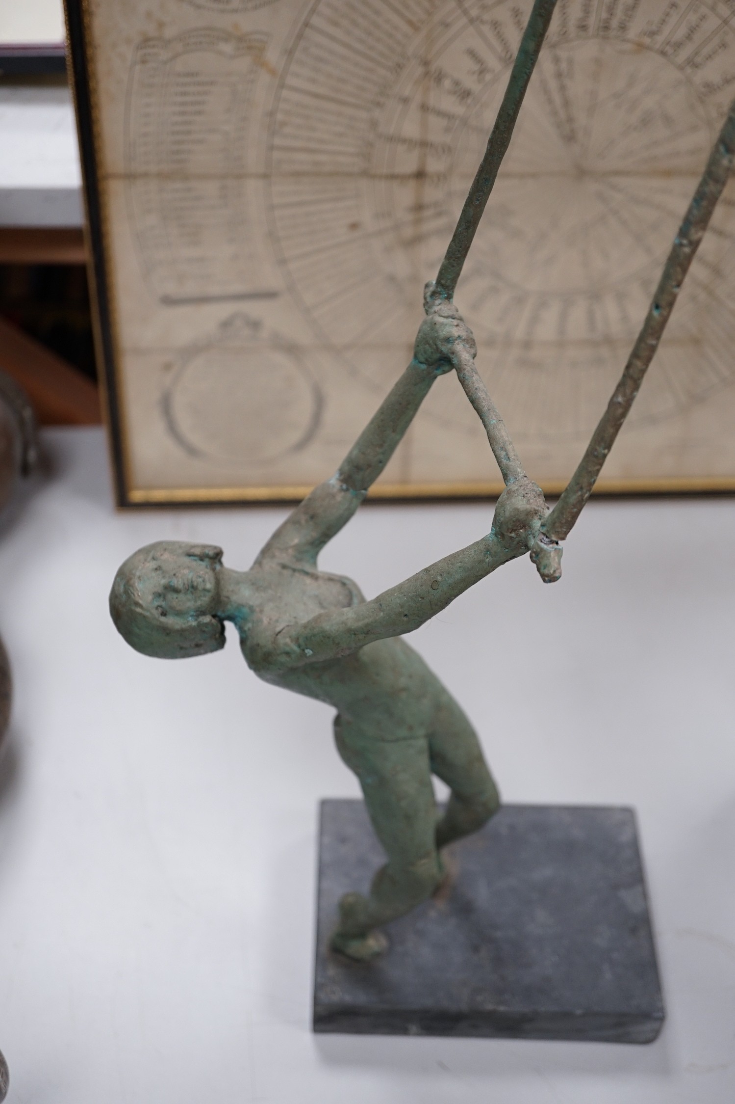 A maquette sculpture of a gymnast in pose swinging on a bar, 48cm tall